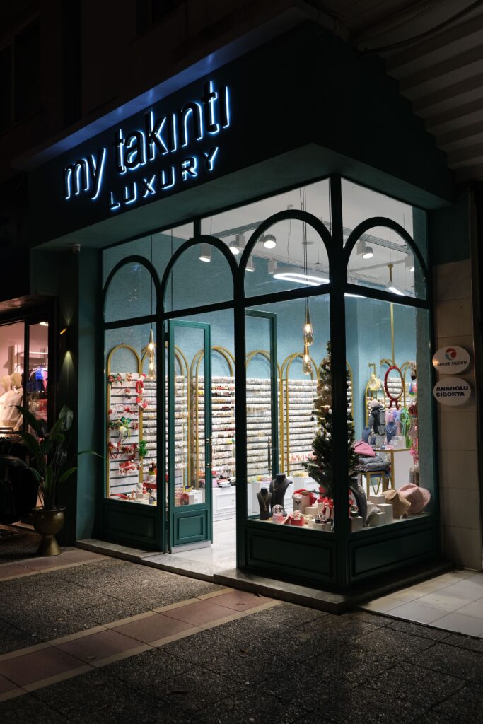 Chic entrance of a luxury store illuminated at night, showcasing elegant displays.